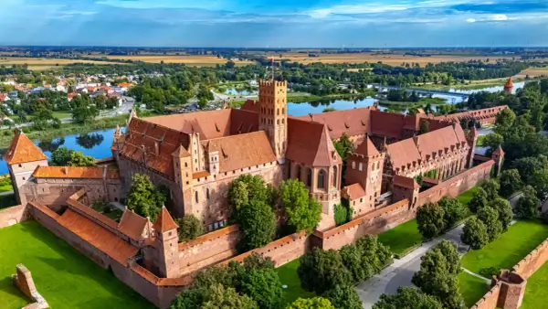 Zamek w Malborku, jedna z największych atrakcji Żuław Wiślanych, majestatycznie wznosi się nad rzeką Nogat.
