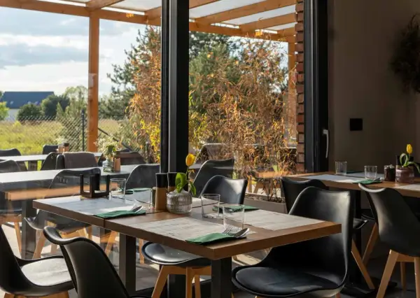 Stolik w restauracji z widokiem na ogród. Idealne miejsce na romantyczną kolację. Polecane restauracje Poznań.