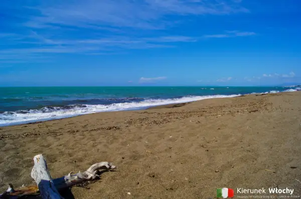 Spokojna plaża nudystów z turkusową wodą i piaszczystym brzegiem.