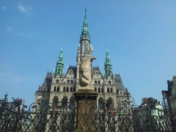 Imponująca budowla z wieżami i rzeźbą na pierwszym planie. Jedna z wielu atrakcji Liberec, która zachwyca turystów.
