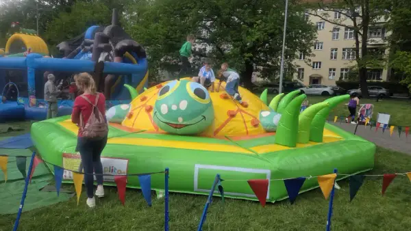 Dzieci bawią się na dmuchanej gąsienicy, jednej z wielu atrakcji na dzień dziecka.