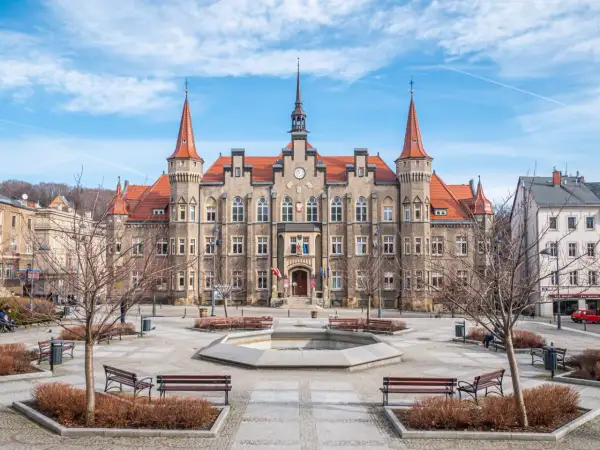 Ratusz w Wałbrzychu, jedna z głównych atrakcji miasta, z fontanną i ławkami na placu.