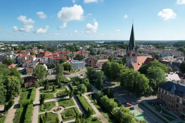 Widok na miasto z lotu ptaka, z dominującą wieżą kościoła i zielonym parkiem. Szczecinek atrakcje zachęcają do spacerów.